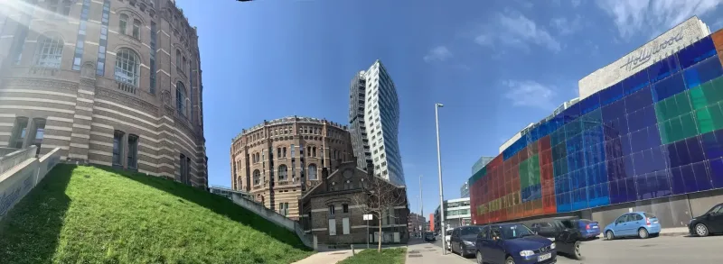 Gasometer in Wien mit modernem Hochhaus von der Guglgasse aus gesehen.