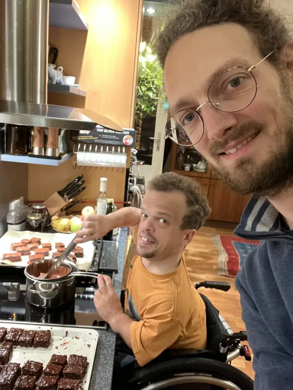 Persönlicher Assistent steht in der Küche und unterstützt beim gemeinsamen Kochen.