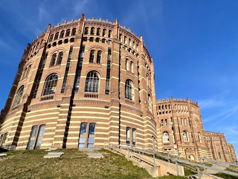 Gasometer bei sonnigem Wetter und strahlendblauen Himmel. Historische Ziegelfassade.