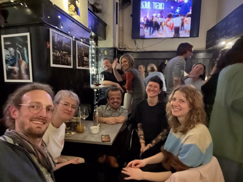 Persönliche Assistentinnen und Persönliche Assistenten beim Teammeeting vom Assistenzteam in einer Jazz-Bar in lockerer Atmosphäre am Abend.