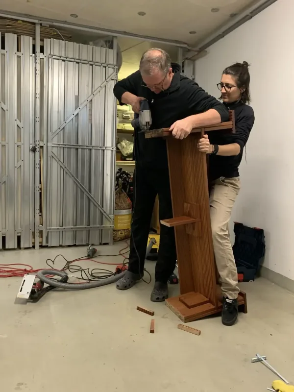 Persönliche Assistentin hilft beim Dienst mit kleinen Handgriffen beim Zusammenschrauben von Möbeln aus einem schwedischen Möbelhaus.
