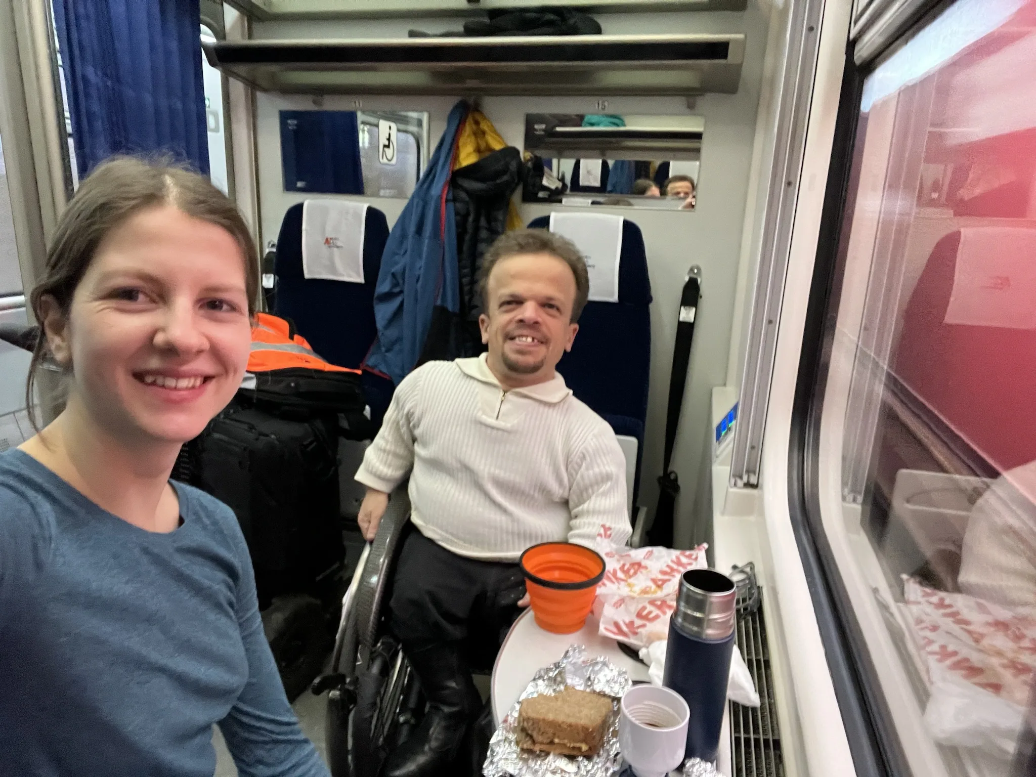 Unterstützung auf Bahnreisen durch das Assistenzteam. Assistentin Simone assistiert im Zug.