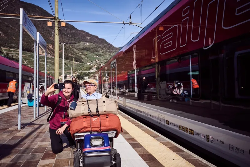 Persönliche Assistenz auf einer Reise mit der Bahn. Die Persönliche Assistenz unterstützt am Bahnsteig bei der Mobilität.