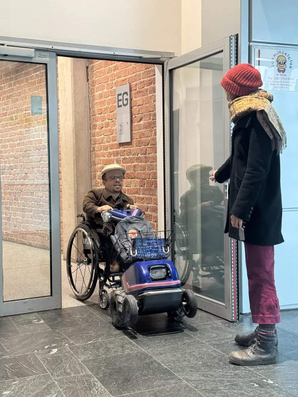 Unterstützung in der Mobilität durch die Persönliche Assistenz. Hier beim Türöffnen